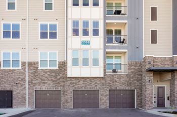 Apartment building with garage doors and balconies.